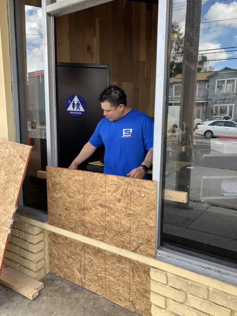Man boarding up window