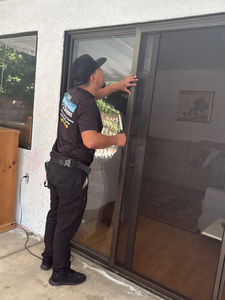 Impact-damaged glass window on a home being inspected for emergency mobile replacement.